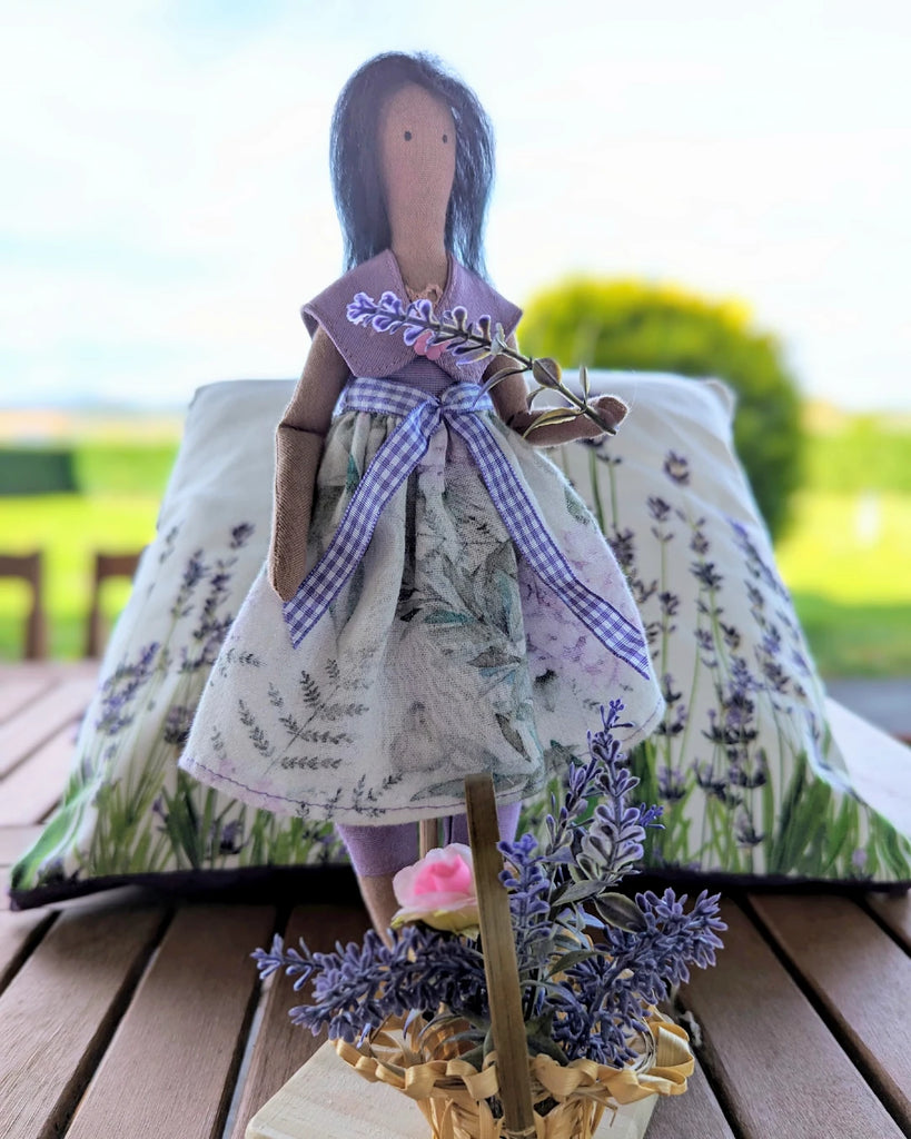 poupée en tissu debout sur socle en bois devant panier fleurs de lavande