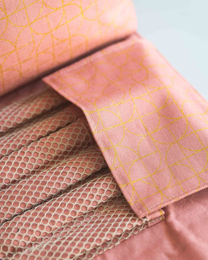 Gros plan sur le range-pinceaux en mesh beige à l’intérieur de la trousse.