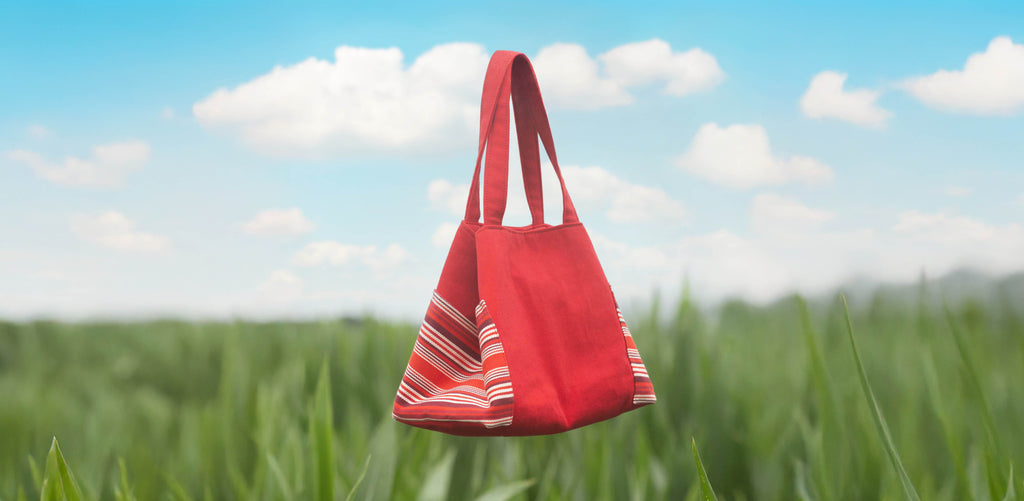 sac rouge au dessus d'un champ sous un ciel bleu