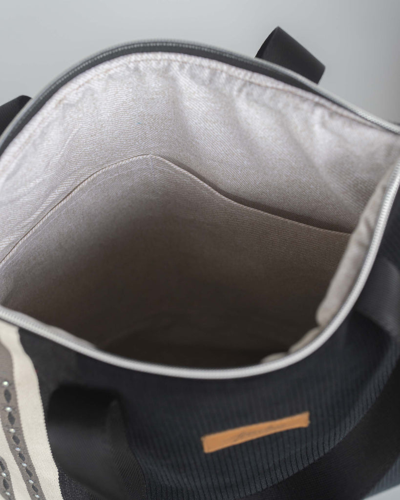 Intérieur du sac velours noir et blanc : tissu beige , 2 poches.