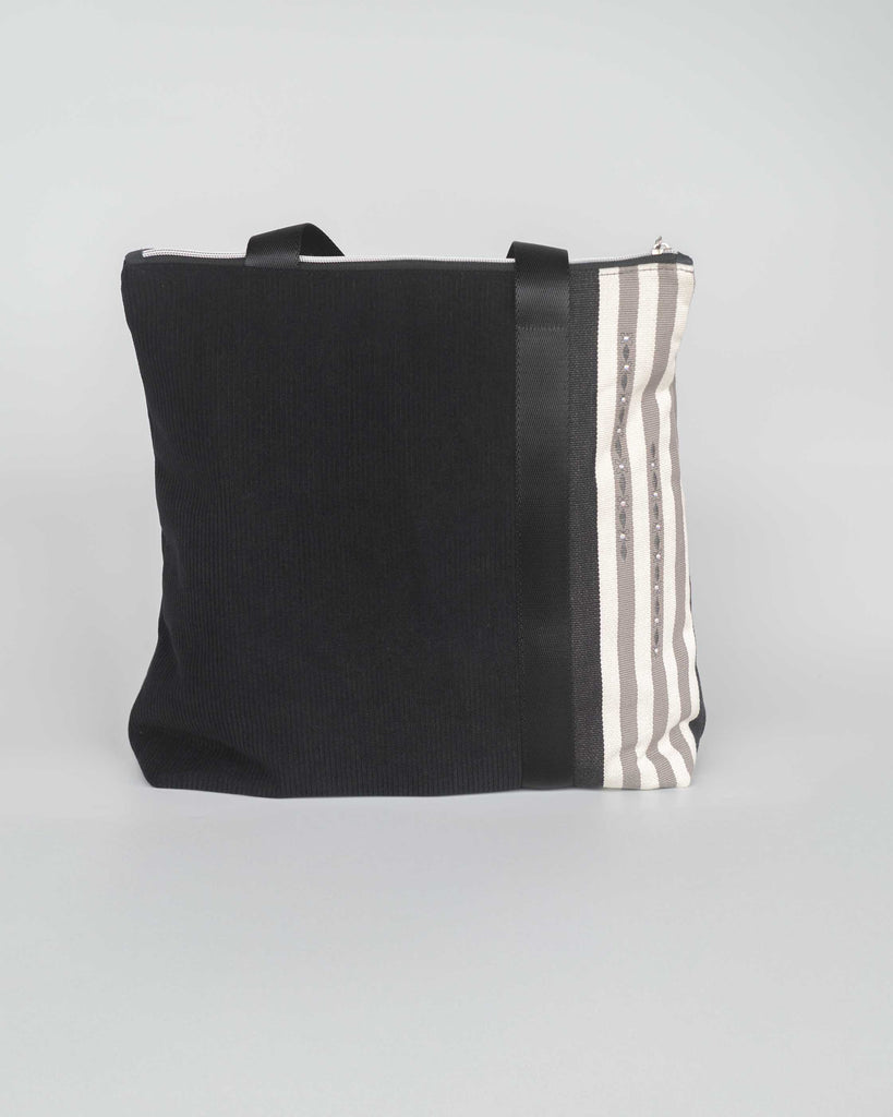 sac velours noir avec rayures noires et blanches sur un coté