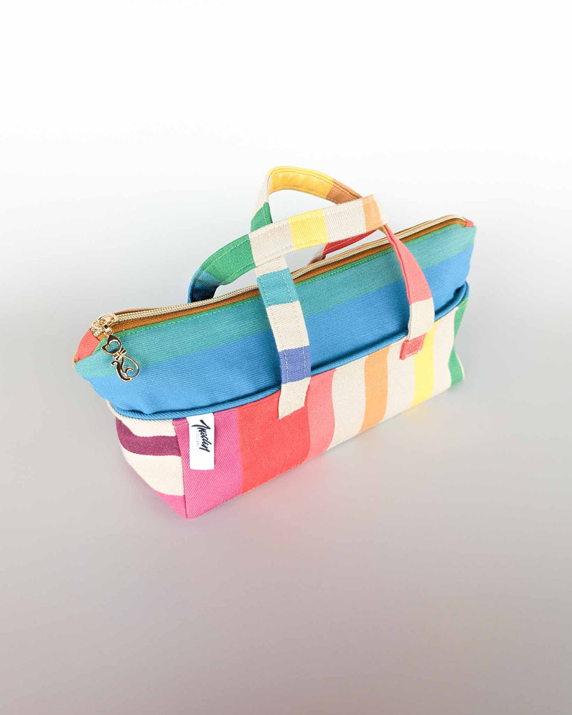 Trousse Argia en tissu basque coloré, vue de trois-quarts fermée avec sa fermeture éclair dorée.