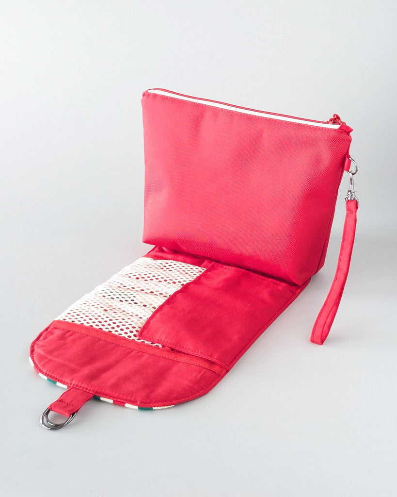 Trousse maquillage rouge ouverte, rabat déployé, rangement pinceaux filet écru.