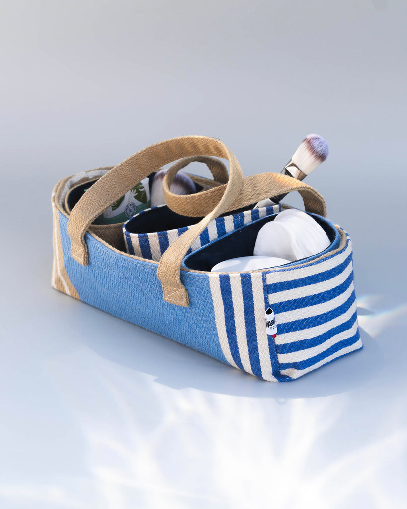  Trousse tissu rayée bleu blanc beige ouverte, contenant effets de maquillage