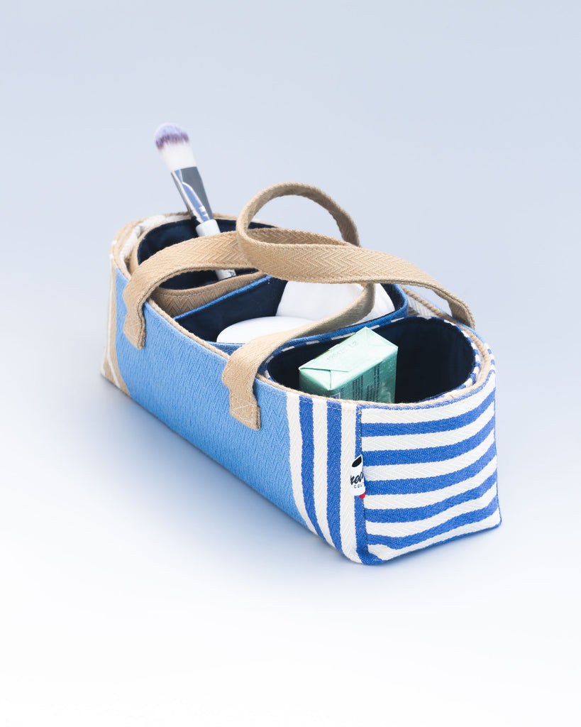 Trousse ouverte de profil, avec des poches amovible et des produits de beauté visibles